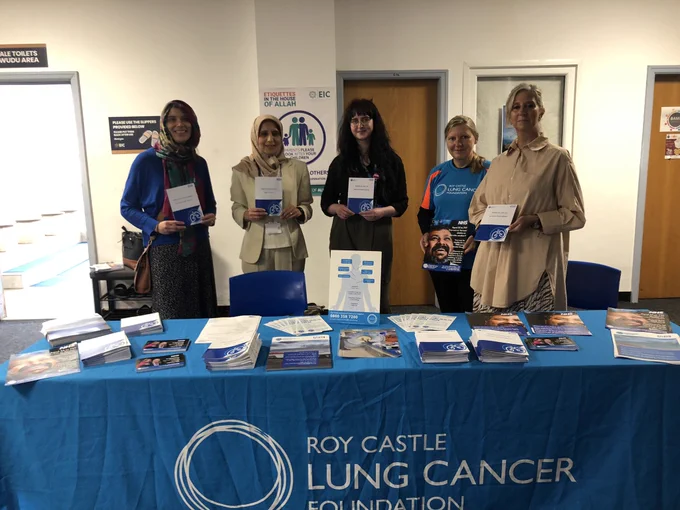 Staff stand holding information leaflets at a stall at the EIC mosque.