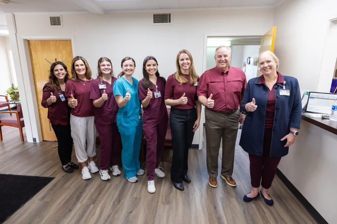 Leann Horsely and Mark Welsh pose for a group photo with nursing and medicine students and health care leaders and staff inside the Frontera Clinic.