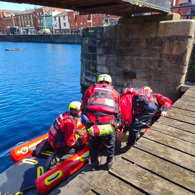 Firefighters removing casualties from a boat 
