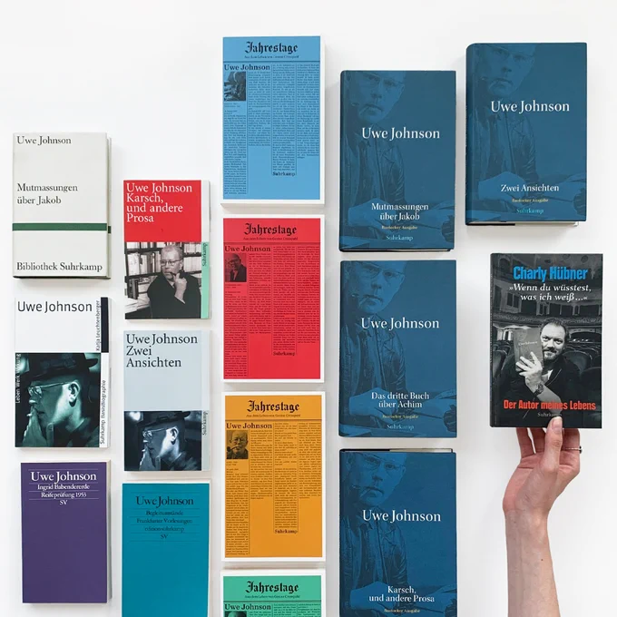Verschiedene Bücher von Uwe Johnson liegen auf weißem Hintergrund nebeneinander. Eine Hand hält auf der rechten Seite des Bildes die Neuerscheinung von Charly Hübner: »›Wenn du wüsstest, was ich weiß ...‹ Der Autor meines Lebens«.