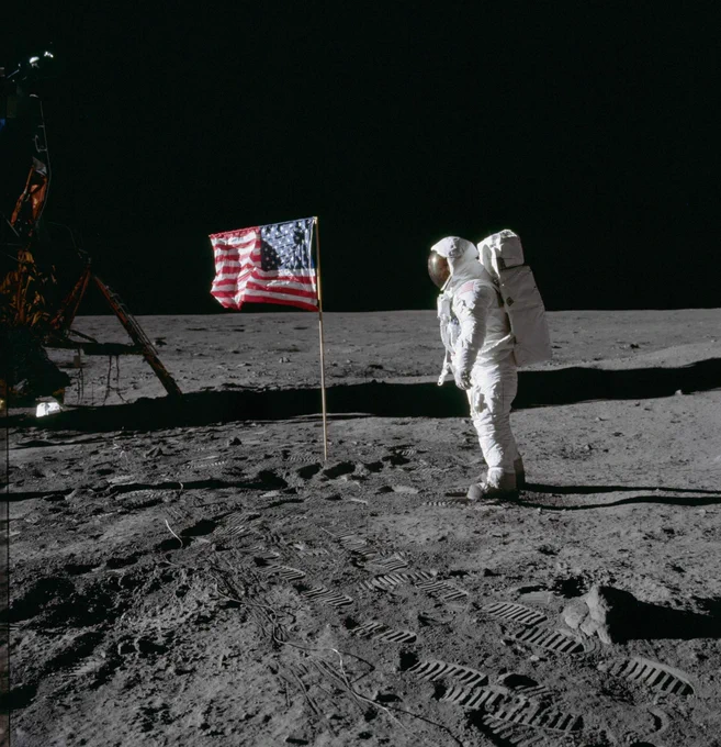 Astronaut Edwin E. Aldrin Jr., lunar module pilot of the first lunar landing mission, poses for a photograph beside the deployed United States flag during an Apollo 11 extravehicular activity on the lunar surface. The Lunar Module is on the left, and the footprints of the astronauts are clearly visible in the soil of the moon. Credit: NASA/Neil Armstrong