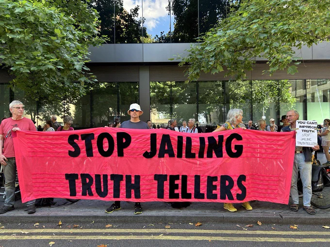 Banner “Stop Jailing Truth Tellers” held as the #WholeTruthFive” are sentenced to 4 and 5 years in prison. 
Photo: B.Kelly