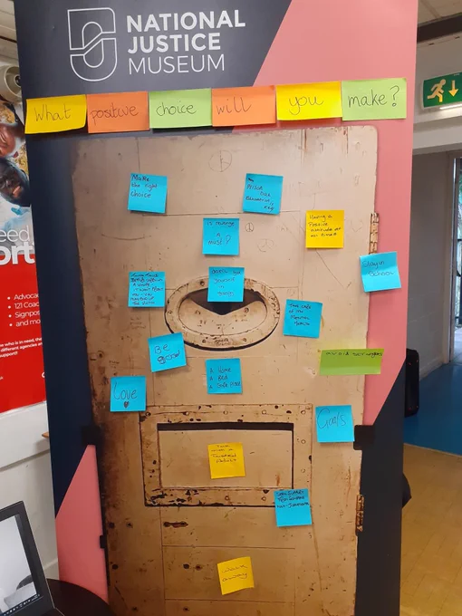 Banner with a cell door picture and post it notes all over it.