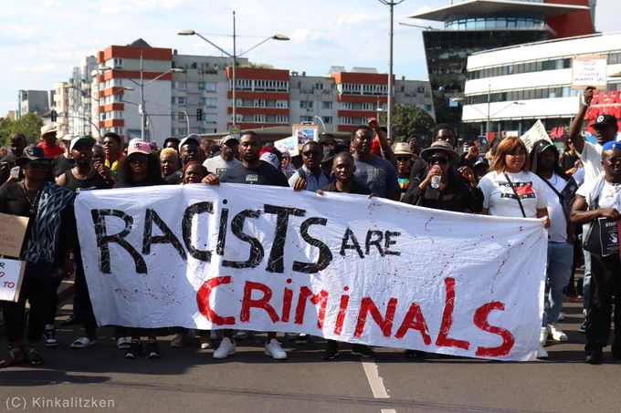 Banner: "Racist are criminals".