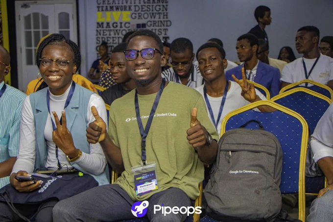 Bukola smiling with his thumbs up to the camera. Esther showing the peace sign with a wide smile.