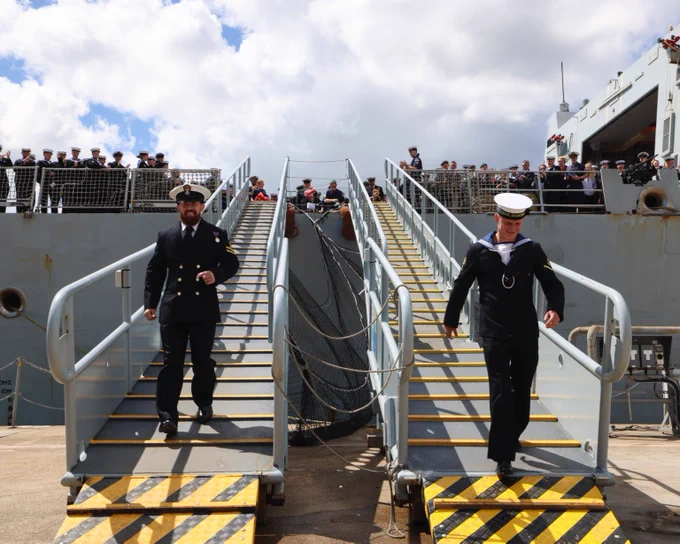 First members of the ship's company leaving HMS Diamond to greet family.