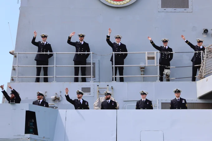 The crew of HMS Diamond waving to their families.