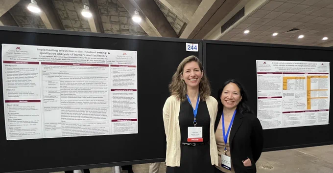 Drs. Debbie Pestka and Genevieve Melton-Meaux standing in front of their two poster abstracts.
