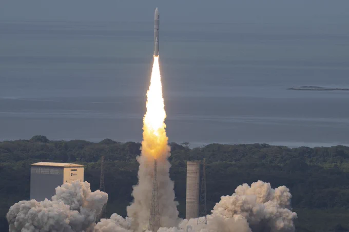 Ariane 6 lifts off from the green rainforest of French Guiana leaving behind a bright plume of smoke.