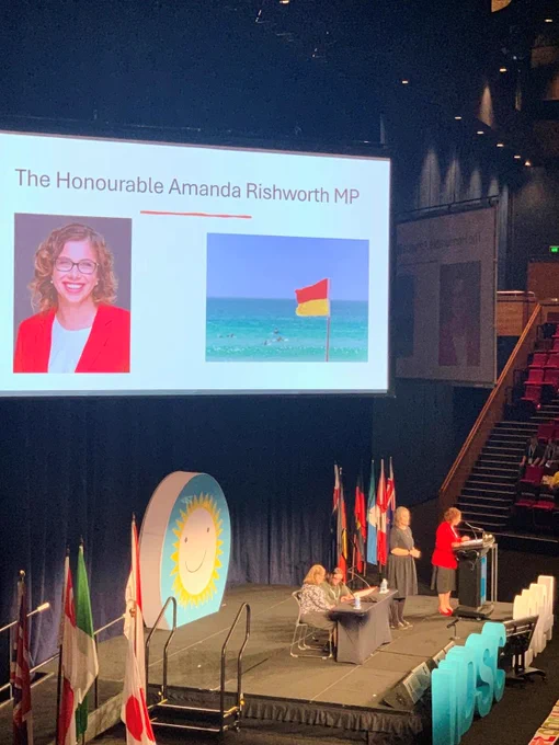 Power point presentation displaying image of Amanda Rishworth MP at the opening ceremony of the World Down Syndrome Congress.