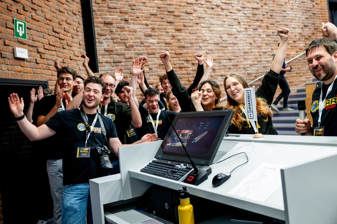 Het studententeam gooit de handen in de lucht van blijdschap na een succesvolle lancering. 