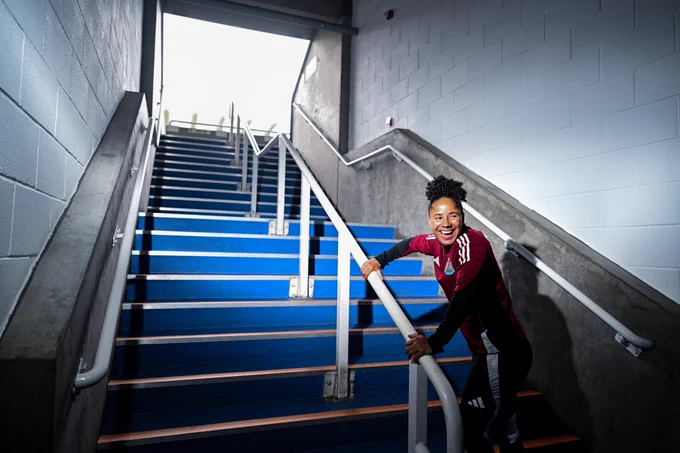 Stokes smiles as she climbs the stairs into the Gallowgate End.