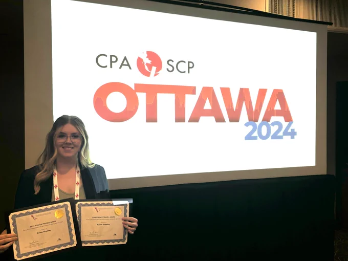A photo of Krista holding both of her awards.