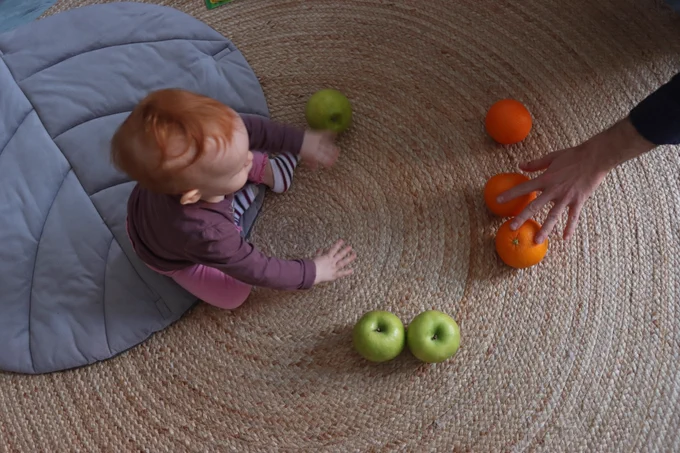 A baby learning words and numbers through play with their caregiver. Photo: Peter Lengyel-Szabo 
