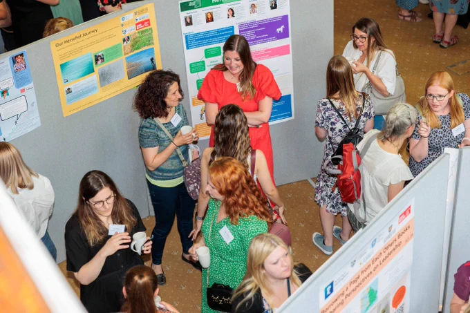 Technicians networking around posters at Herschel celebration event 2022