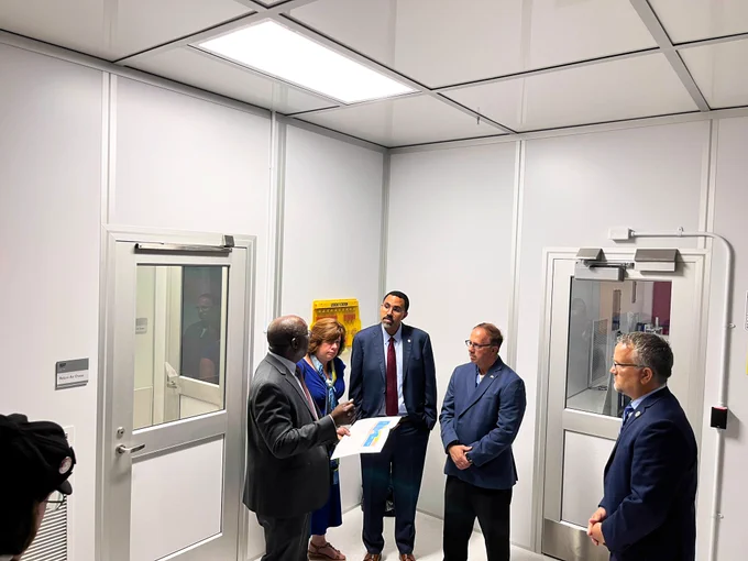 Chancellor King stands with officials and surveys a map of a new learning space