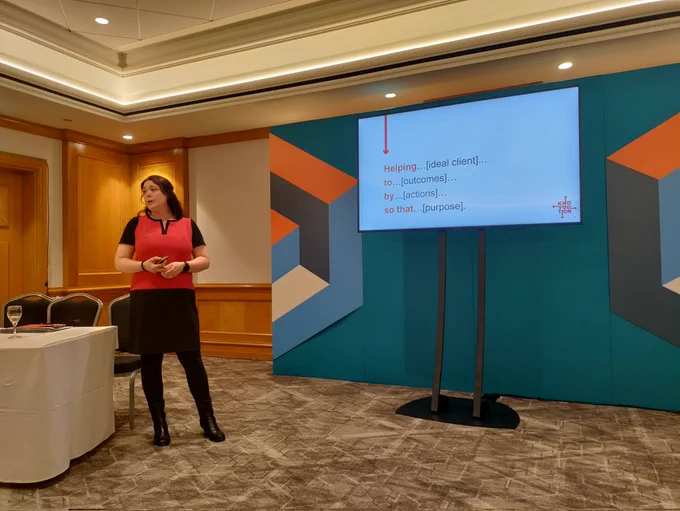 Janine Weightman speaking in front of a screen