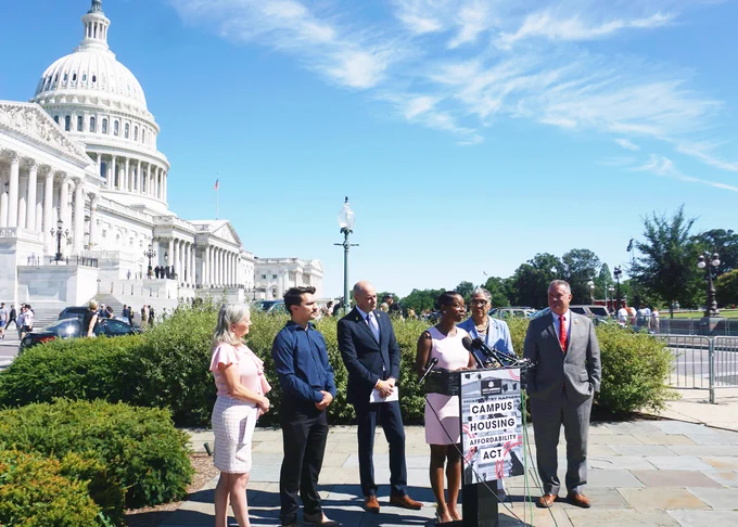 Foster Youth expert speaking at the podium in front of the Capitol in a pink dress