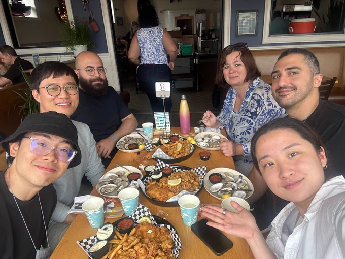 (left to right) George Wong, Dr.  Jung, Hootan Rosahdel, Prof. Diaconescu, Nima Adhami, Shiyun Lin. (on the table) fries accompanying unspecified fried protein options, and in front of each person are dishes containing clams.