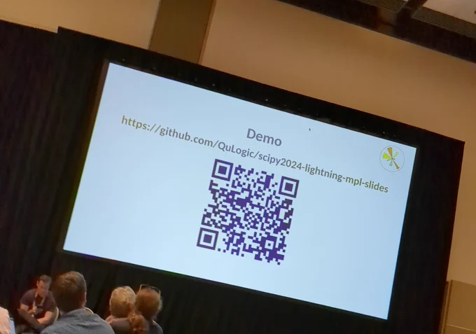 Tilted image of slide made in Matplotlib. Slide has logo in upper right corner, title is demo, then url to repo for slides, and very large QR code underneath. 
