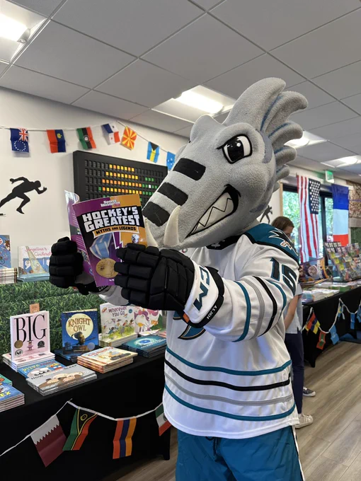 San Jose Barracuda’s Frenzy reading a book at a book fair called “Hockey’s Greatest Myths and Legends”