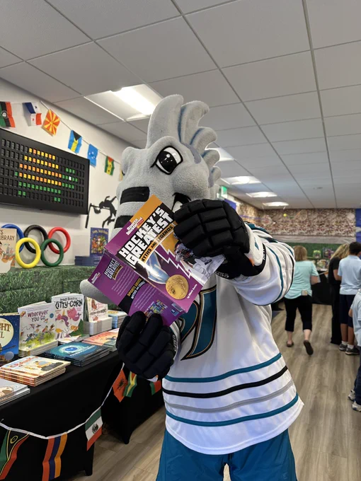 San Jose Barracuda’s Frenzy reading a book at a book fair called “Hockey’s Greatest Myths and Legends”