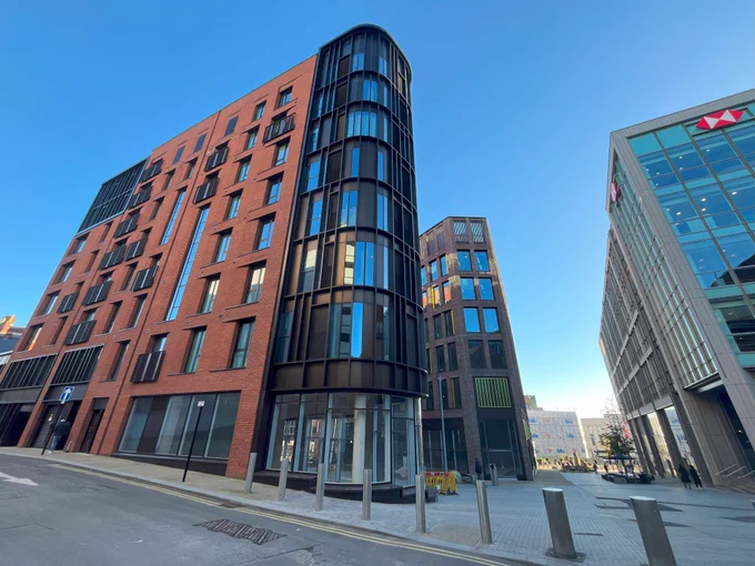 Picture shows Burgess House, a residential development in the Heart of the City, to the foreground is a line of bollards with further buildings behind and to the right.