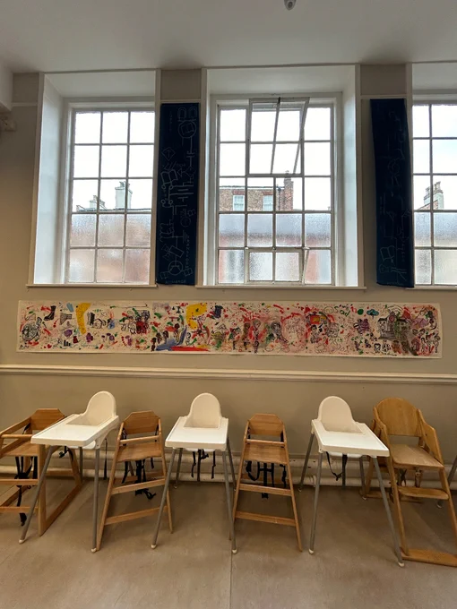 A long real of paper with drawings, paintings and writing on.