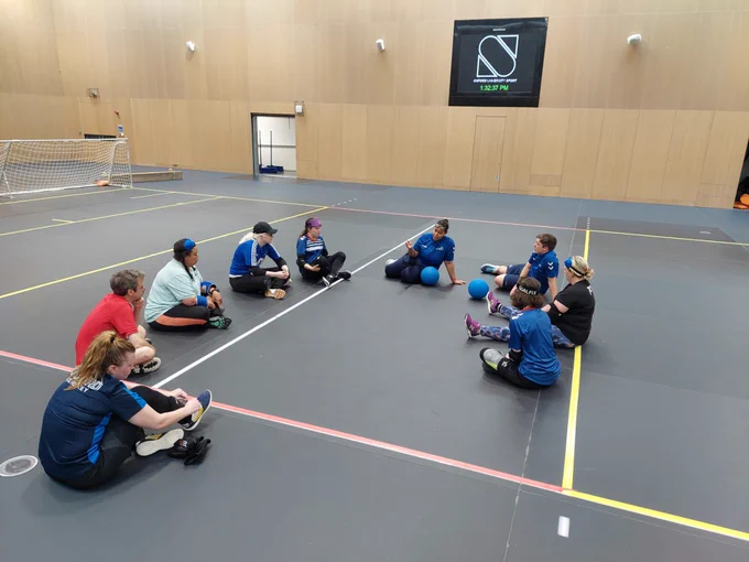 The group of attendees and coaches sat in a circle in the middle of the hall. Alex Ulysses is sat at the top the circle explaining the next part of the session we were going into.