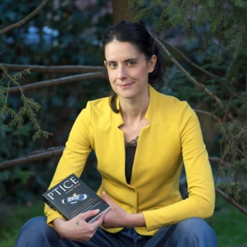 Antica Culina holding a book called "PTICE"