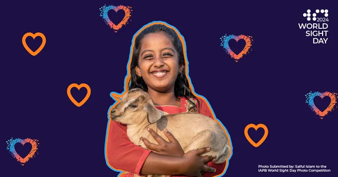 Dark background with multi-colored hearts. A girl holding a baby goat is in the middle smiling. 