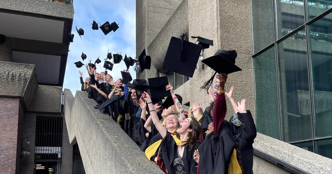 A photo of students throwing their graduation caps in the air
