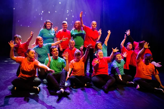 The YAC on stage with their arms in the air