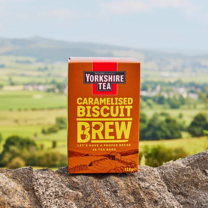 A box of Yorkshire Tea Caramelised Biscuit Brew, sat on a wall.