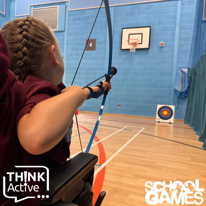 Image shows a girl shooting a bow in a wheelchair above the School Games and Think Active logos