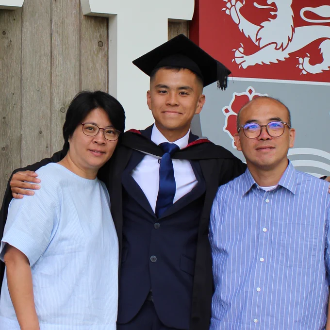 A graduating student poses with parents