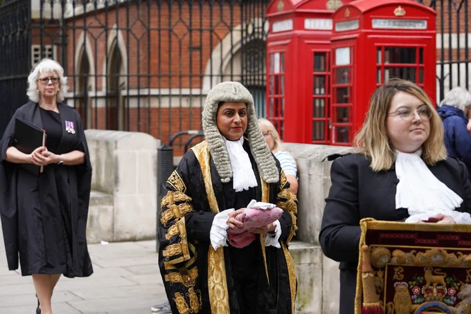 The Lord Chancellor wears a white barrister's wig and black and gold ceremonial robes as she walks towards the Royal Courts of Justice