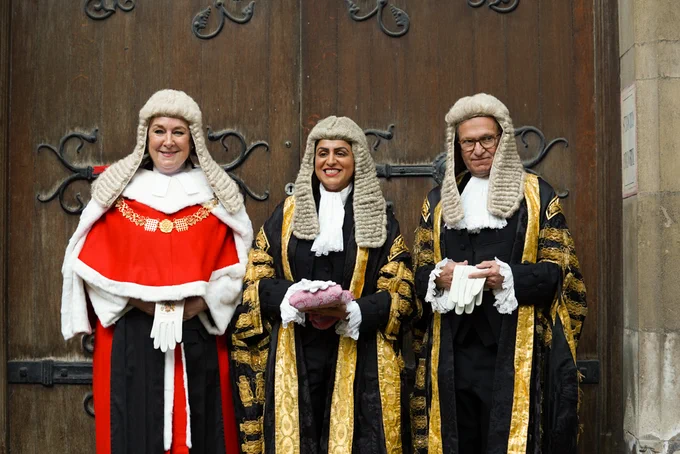 The Lord Chancellor stands in the middle in front of the doors of the Royal Courts of Justice with the Lady Chief Justice in red robes to the left