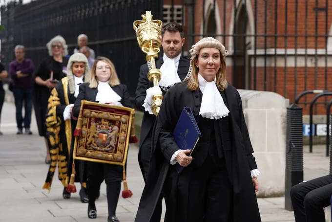 A procession towards the Royal Courts of Justice led by the Permanent Secretary with the Lord Chancellor behind her