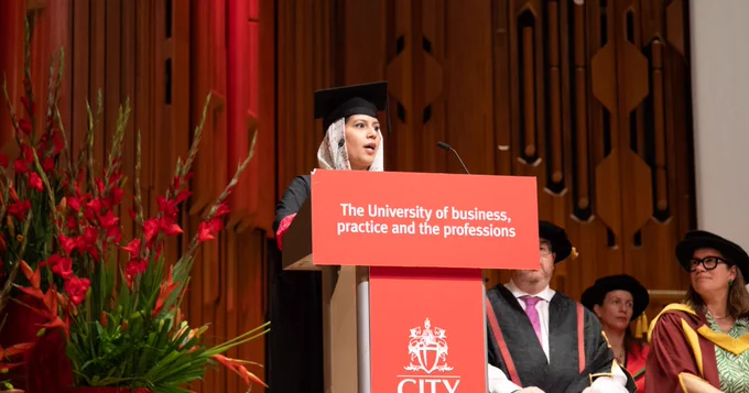 A photo of Fatemeh standing at the podium delivering her speech