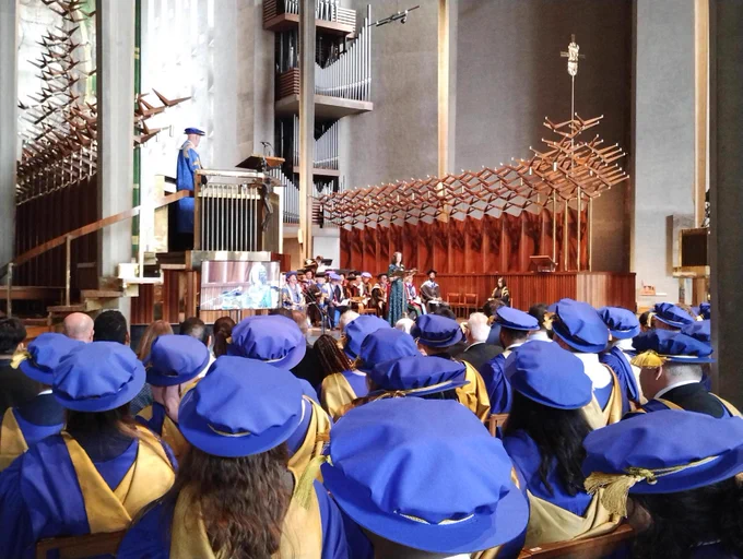 Graduation ceremony showing back of blue caps in Coventry Cathedral 