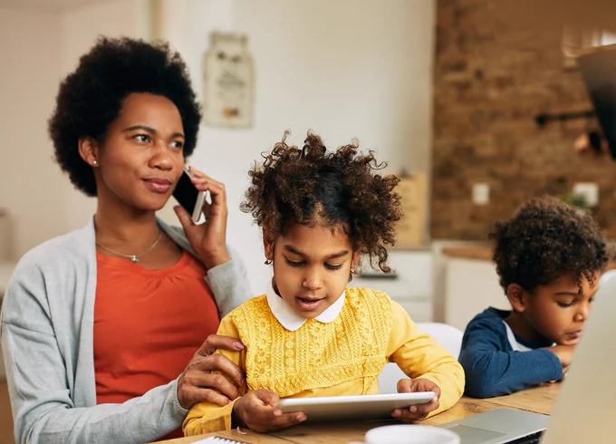 Mom talks on the phone while her two young children play and read