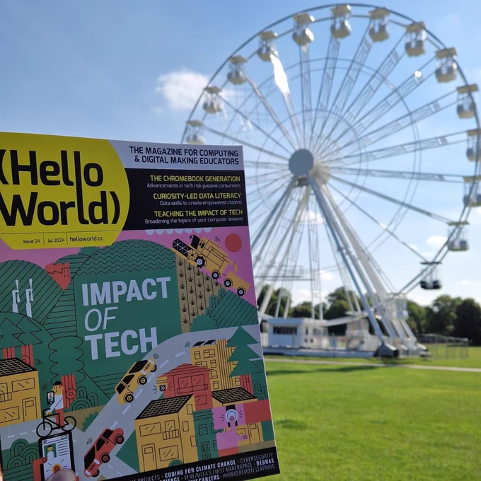 Photo depicting a copy of Hello World, issue 24 in front of a Ferris Wheel in Cambridge.
