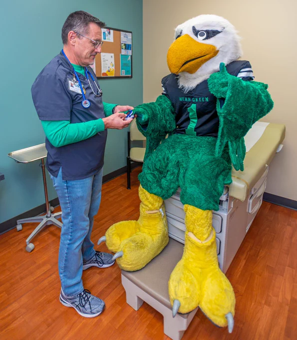Scrappy the Eagle being given a medical check-up by a UNT Student Health and Wellness Center staff member