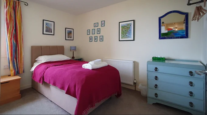 The twin room at the Lighthouse Keeper's Cottage with watercolours of two collies looking at Noss Head lighthouse