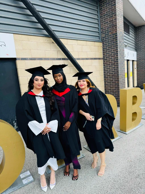 Three graduates smiling at the camera.