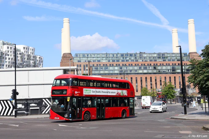 Transport UK LT167 (LTZ1167) is a red New Routemaster as it heads to Hammersmith Bus Station on route 211. In the backdrop is Battersea Power Station, with the four chimneys visible.