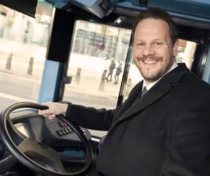 Simon Lightwood MP sitting in the driving seat of a bus