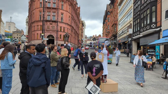 Gisela standing on a soapbox while talking to a small crowd.