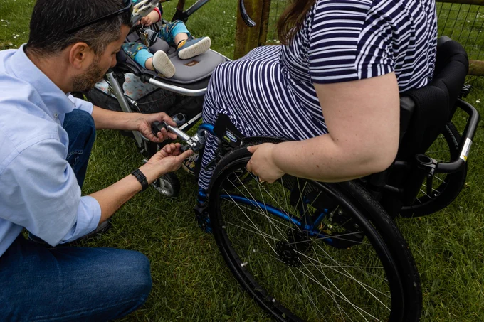 Dario helps to attach and demonstrate the design to a parent while crouching down beside it